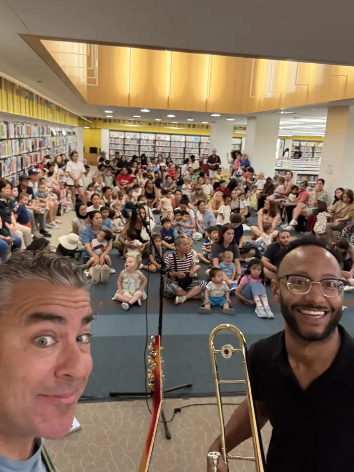 Michael and a librarian in front of a packed library audience